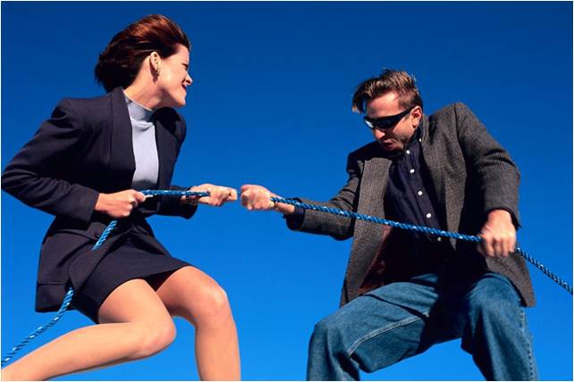 man and woman in business attire in tug of war