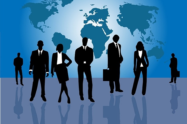 Silhouette of young business people standing in front of a world map