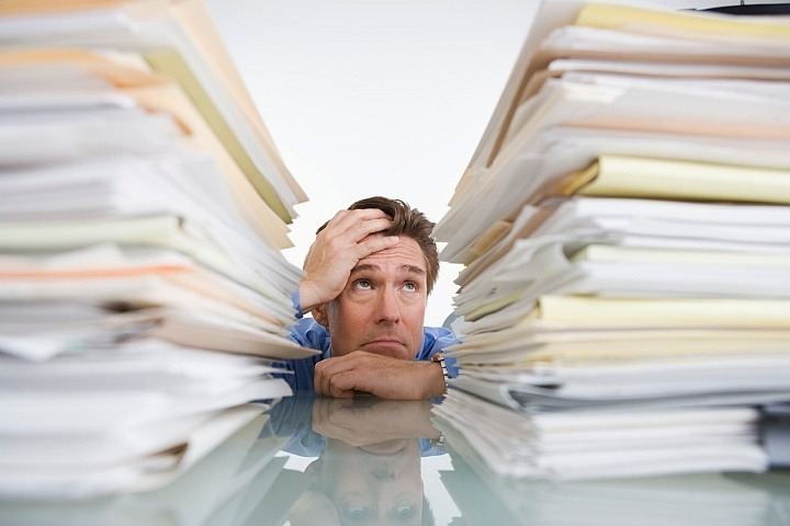 business man buried in two stacks of paperwork