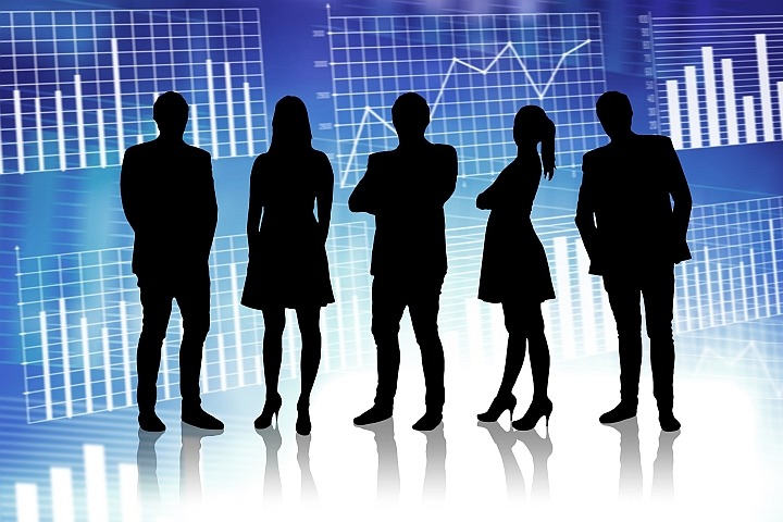 Silhouette of young business men and woman standing in front of graphs