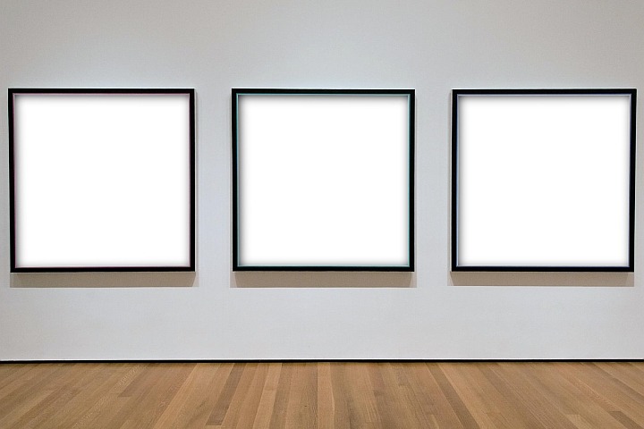Three black picture frames with a white canvas mounted to a wall