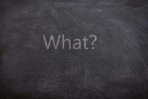 le mot "quoi" écrit sur un tableau noir"what" written on a chalkboard