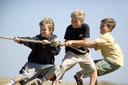 three boys playing tug of war