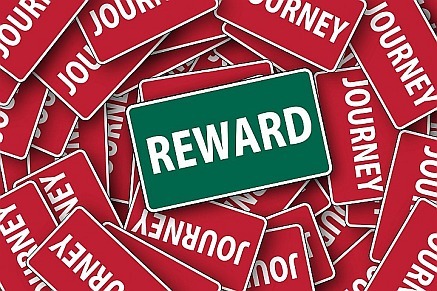 reward sign sitting on top of journey signs